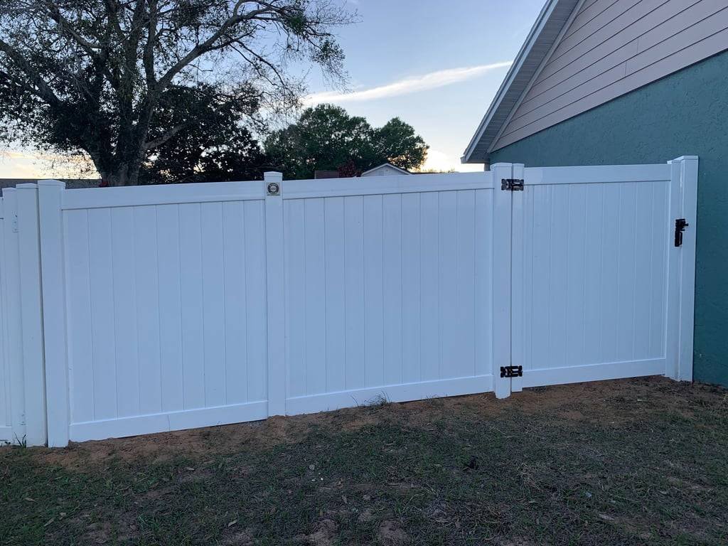White vinyl double gate installed beside a home in Dr. Phillips, FL